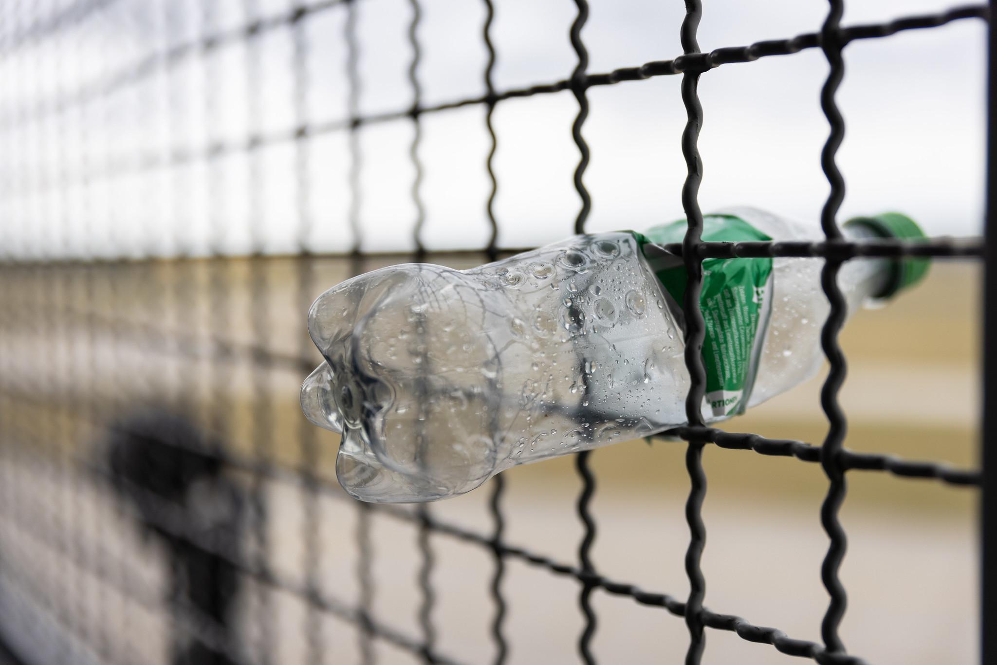 Hannover Airport: Zerdrückte Plastikflasche in Zaun